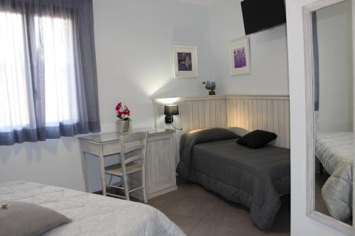 a bedroom with a bed and a desk and a bed at Bed & Breakfasts Conte Perollo in Sciacca