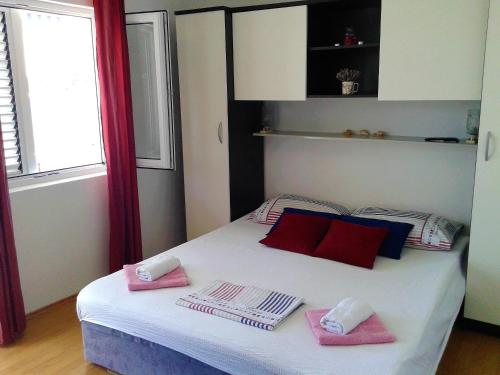 a bedroom with a bed with pink towels on it at Apartment Vesna in Milna