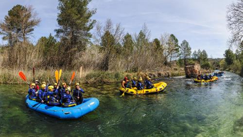a group of people rafting down a river in canoes at Casa Rural La Herradura del río Júcar in Jorquera