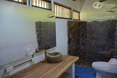 a bathroom with a sink and a toilet in a room at Tinamu Birding in La Manuelita