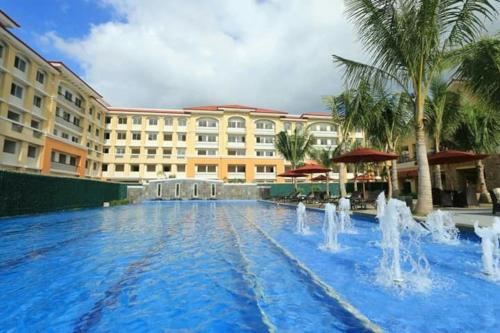 a large swimming pool with fountains in front of a hotel at San Remo Oasis, Citta De Mari in Cebu City