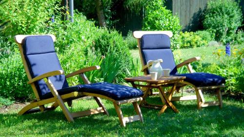 two chairs and a table in the grass at JANISCHs Fewo im Spreewald, Terrasse, großer Garten und Blick inklusive in Unterspreewald