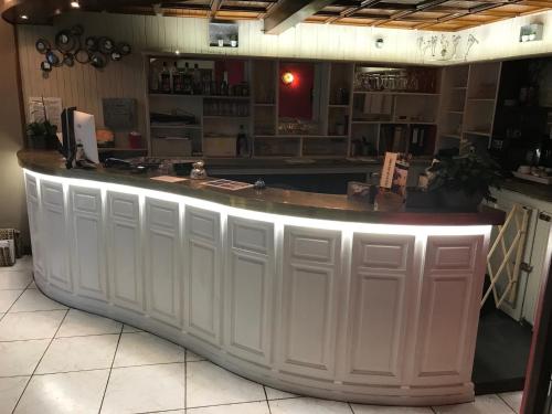 a large white bar in a kitchen with a counter at Hôtel Le P'tit Monde in Montignac