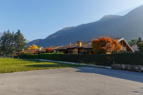 a house with a fence in front of a mountain at CASA VACANZA Residence Lago di Endine in Monasterolo del Castello