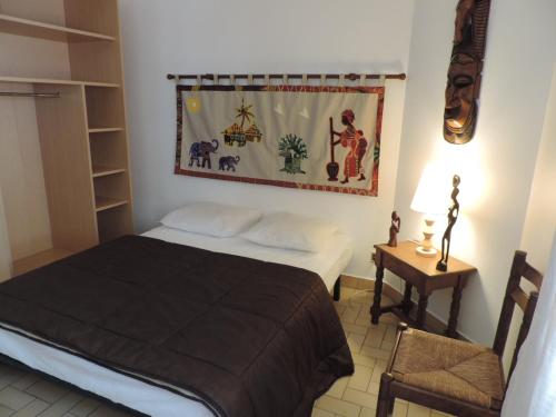a bedroom with a bed and a table with a lamp at Gite Le Bois Fleuri in Illiers