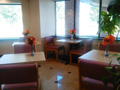 a restaurant with tables and chairs with flowers on them at Americas Best Value Inn Horseheads in Elmira