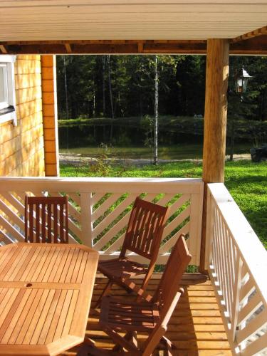 two chairs and a wooden table on a porch at Kuusitorppa in Varpaisjärvi