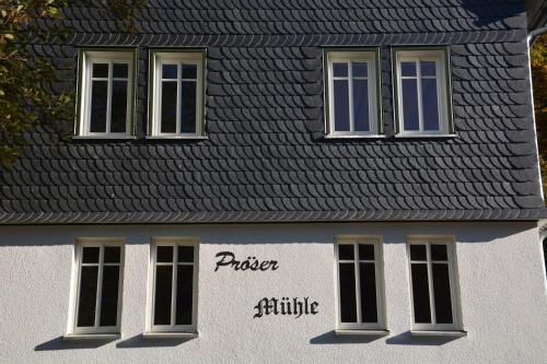 a building with three windows and a black roof at Pröser Mühle in Weilmünster