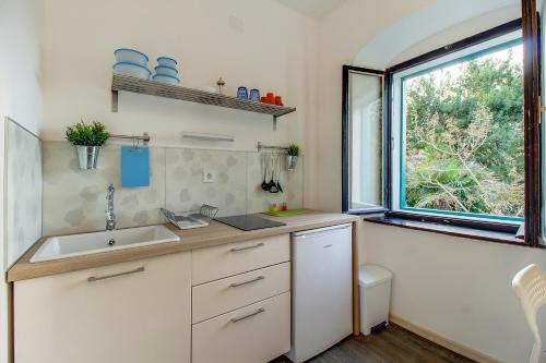 a small kitchen with a sink and a window at BigBlue house in Veli Lošinj