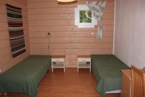 a room with two beds and a window at Kuusitorppa in Varpaisjärvi