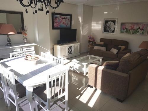 a living room with a white table and a couch at GEMELOS 26 APARTMENTS - Benidormland in Benidorm