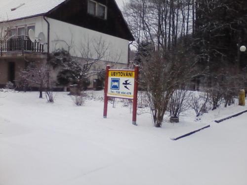 a sign in the snow in front of a house at ubytování v apartmánu in Mladkov