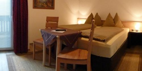 a bedroom with a bed and a table and chairs at Pension Mühle in Zell am See