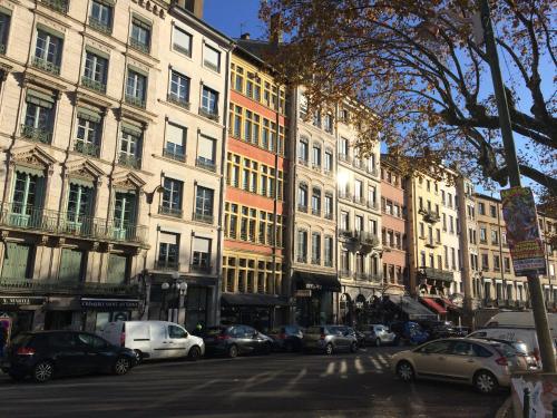 une rue de la ville avec des voitures garées devant des bâtiments dans l'établissement Studio Charme et Confort aux Cordeliers, à Lyon