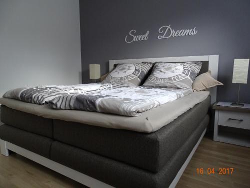 Una cama en un dormitorio con la palabra final sueños en la pared en Ferienwohnung Haus Nr. 11, en Warendorf