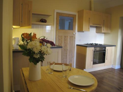 a kitchen with a table with a vase of flowers on it at Bramblhen in Nottingham