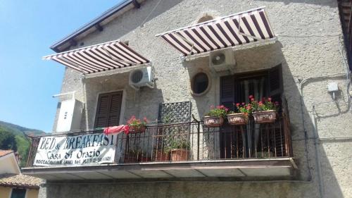 a building with potted plants on a balcony at B&B Casa di Orazio Giubileo 2025 in Roccagiovine
