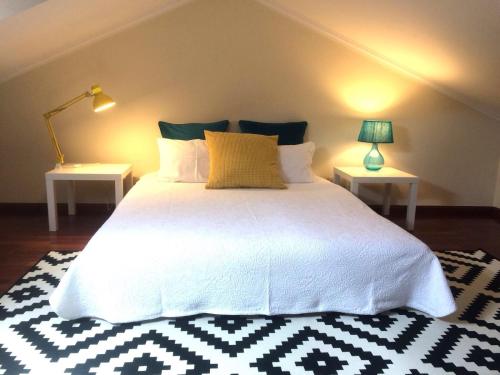 1 dormitorio con 1 cama blanca grande y 2 mesas en Apartment Vedória, en Viana do Castelo