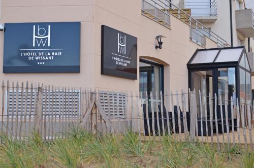 a building with a fence in front of it at Logis- Hôtel de la Baie de Wissant & Appartements in Wissant