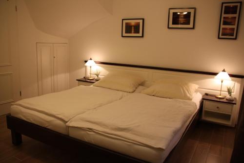 ヴェスターラントにあるWitt-Hingstのベッドルーム(白い大型ベッド、ランプ2つ付)