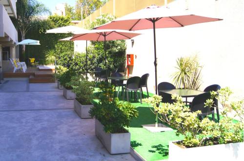 a patio with tables and chairs and umbrellas at Soltigua Apart Hotel Mendoza in Mendoza