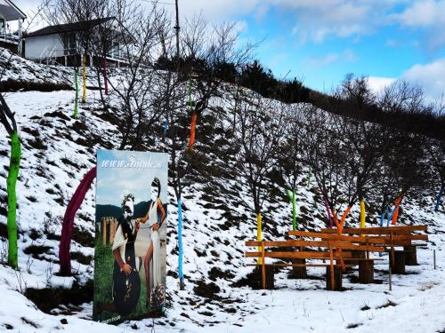 a sign in the snow next to a bench at Dream Tricule in Sviniţa