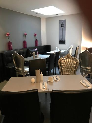 a dining room with tables and chairs and tablesearcher at Hotel Lindenhof in Düsseldorf