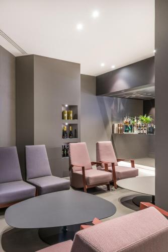 a waiting room with pink chairs and a table at Point Hotel in Piove di Sacco