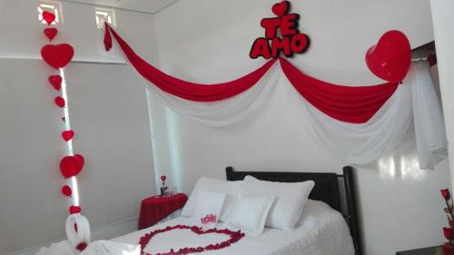 a bedroom with a red and white bed with a heart banner at Club campestre el Peñón de Apulo in Apulo