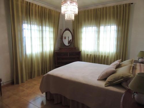 a bedroom with a large bed and a chandelier at Berdullas in Vilagarcia de Arousa