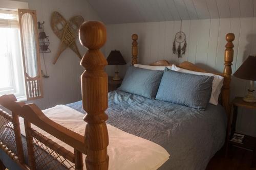 a bedroom with a wooden bed with blue pillows at Yamachiche P.Q. in Yamachiche