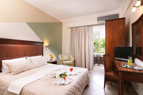 a hotel room with a bed and a desk and a television at San Antonio Beach Apartments in Potos