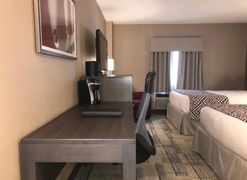 a hotel room with a desk and a bed at Best Western Colonel Butler Inn in Niagara on the Lake