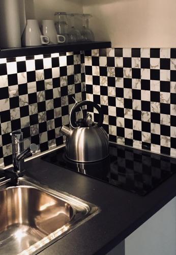une bouilloire assise sur un comptoir à côté d'un évier dans l'établissement Studio Toulouse Centre Patte d'Oie, à Toulouse