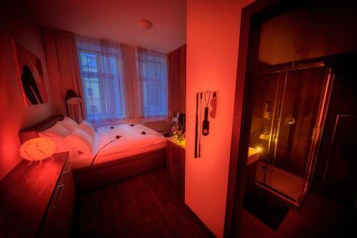 a red bedroom with a bed and a window at Fifty Shades of Gray studio, city center in Hradec Králové