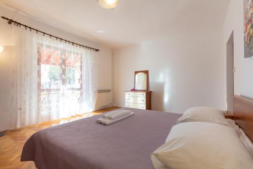 a white bedroom with a bed and a window at Vacation home Duilo in Donji Zemunik