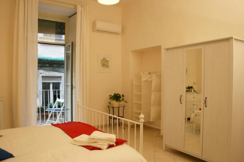 ナポリにあるcasa grecaのベッドルーム1室(ベッド1台付)、スライド式ガラスドアが備わります。