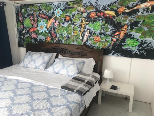 una camera da letto con un letto e un dipinto sul muro di Hibiscus House a San Andrés
