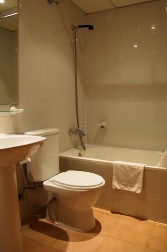 a bathroom with a toilet and a sink and a tub at Bertur Gran Reserva Comte Empuries in Empuriabrava