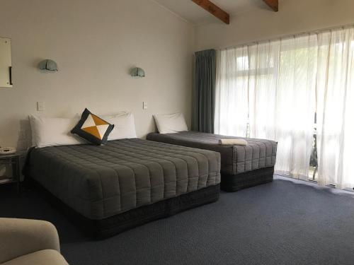 a bedroom with two beds and a window at Edelweiss Motel in Paihia