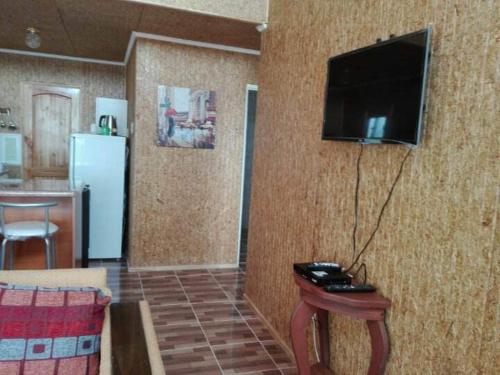 a living room with a television on a wall at Estancia Pacífico in Punta de Choros