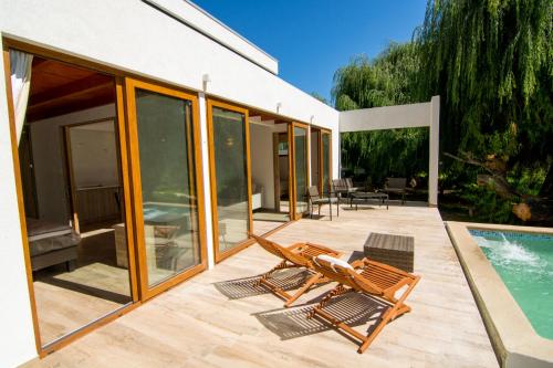 a patio with two chairs and a swimming pool at Aldea del Valle - Elqui Villas, Pisco Elqui in Pisco Elqui