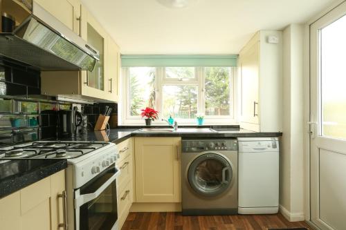ロンドンにあるModern Flat Near Central Londonのキッチン(洗濯機付)、窓が備わります。