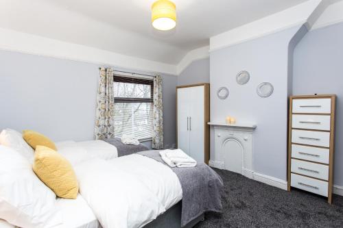 een slaapkamer met 2 bedden en een open haard bij Northwood Park View in Stoke on Trent