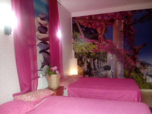 two beds in a room with pink sheets at Residencia Santiago Mallorca in Cala Figuera