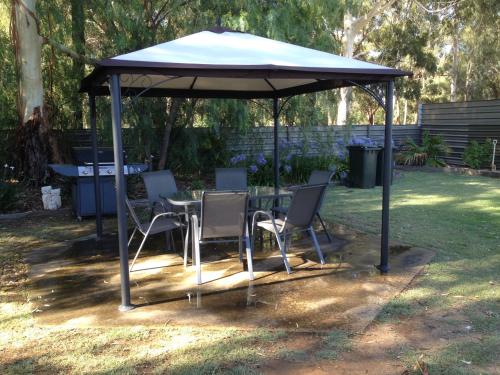 a table and chairs under an umbrella in a yard at Kyabram Country Motel in Kyabram