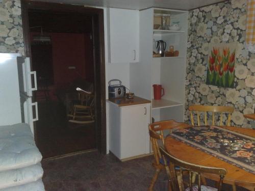 a kitchen and dining room with a table and a small kitchen at Christinagården Guesthouse in Ramsele