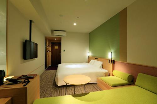 a hotel room with a bed and a couch at THE SINGULARI HOTEL & SKYSPA at UNIVERSAL STUDIOS JAPAN in Osaka