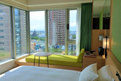 a bedroom with a bed and a large window at THE SINGULARI HOTEL & SKYSPA at UNIVERSAL STUDIOS JAPAN in Osaka