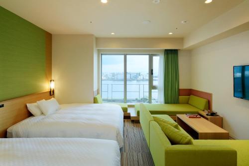 a hotel room with two beds and a couch at THE SINGULARI HOTEL & SKYSPA at UNIVERSAL STUDIOS JAPAN in Osaka